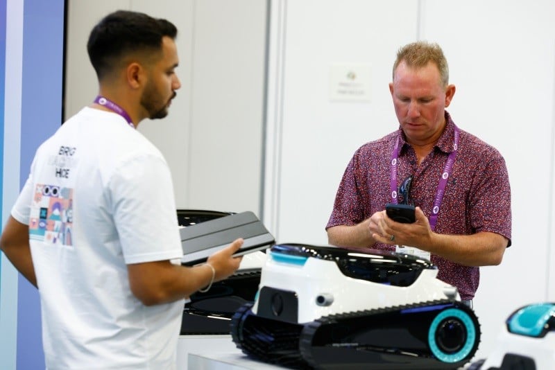 A pool service tech looking at a pool cleaner at International Pool Spa Patio Expo